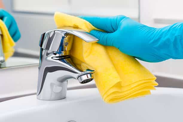 Mão limpando torneira